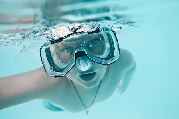 Premium Photo | Boy under water in pool on a blue background