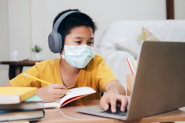 Boy wearing face masks online study at home. | Premium Photo