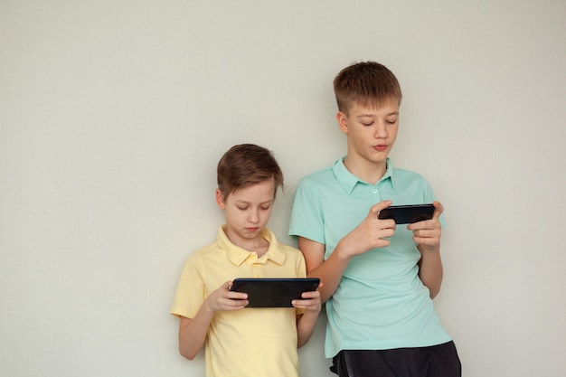 Premium Photo Boys Playing Games On Mobile Phones At Home