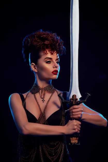 Brave warrior woman keeping big steel sword. | Premium Photo