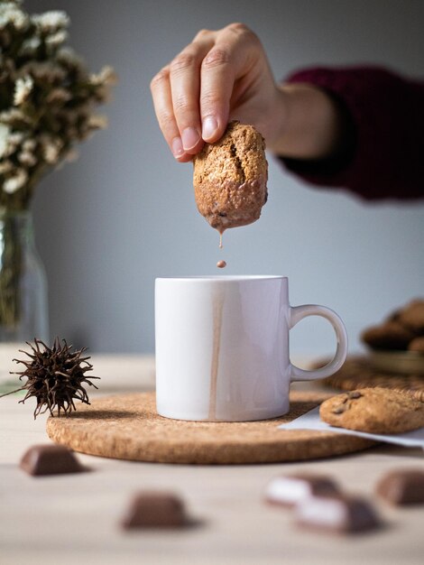 Premium Photo Breakfast With Cookies And Cocoa With Milk A Hand Dipping Oatmeal Cookies With Chocolate Chips Into Cacao English Breakfast Close Up