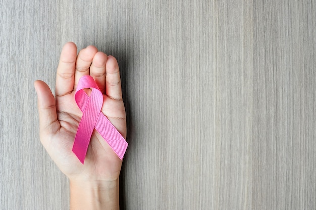 Premium Photo | Breast cancer awareness, woman hand holding pink ribbon