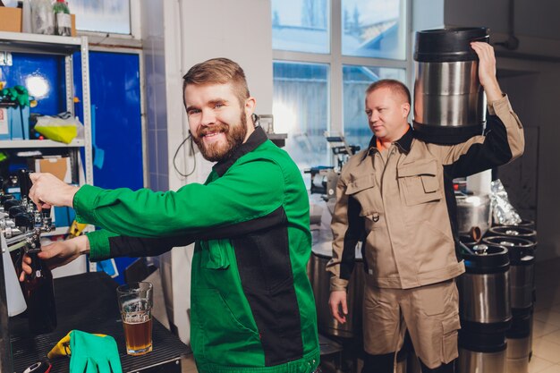 Brewery factory spilling beer into glass bottles on conveyor lines. industrial work, automated production of food and drinks. technological work at the factory. Premium Photo