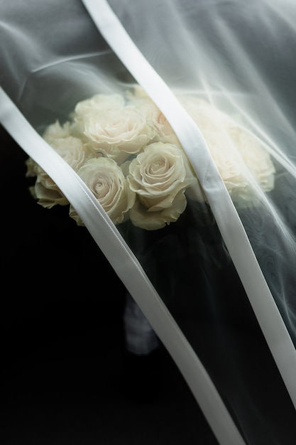 ブライダルベールは結婚式のバラの花束をカバーします 無料の写真