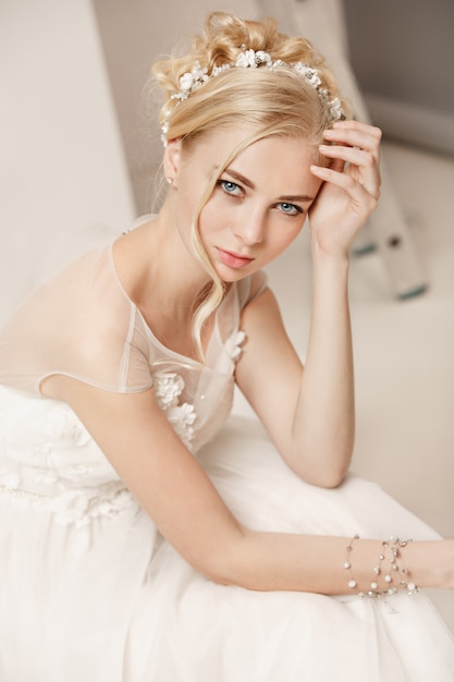 Bride in beautiful dress standing indoors in white studio