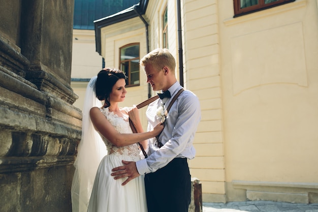 Bride grabbing her groom's suspenders Photo | Free Download