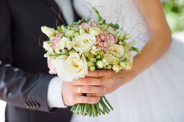 Premium Photo | Bride and groom holding bouquet.