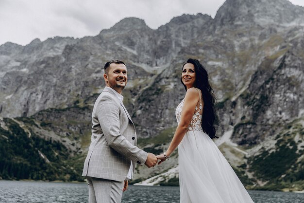 https://image.freepik.com/free-photo/bride-groom-near-lake-mountains-couple-together-against-backdrop-mountain-landscape-morskie-oko-sea-eye-lake-tatra-mountains-poland_233298-1008.jpg