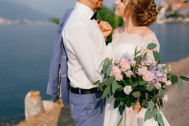 Premium Photo The Bride And Groom Stand Embracing On The Pier The