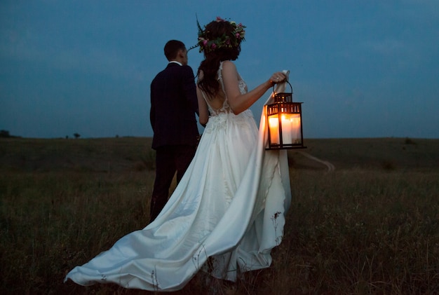 The bride and groom walk at sunset. Premium Photo