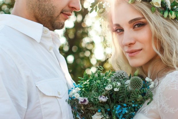 夏の日の白いドレスと花輪と新郎の肖像画の花嫁素朴な屋外の結婚式のコンセプト プレミアム写真