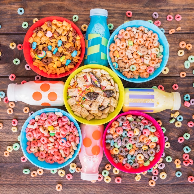 Free Photo | Bright bowls of cereals with milk bottles on table