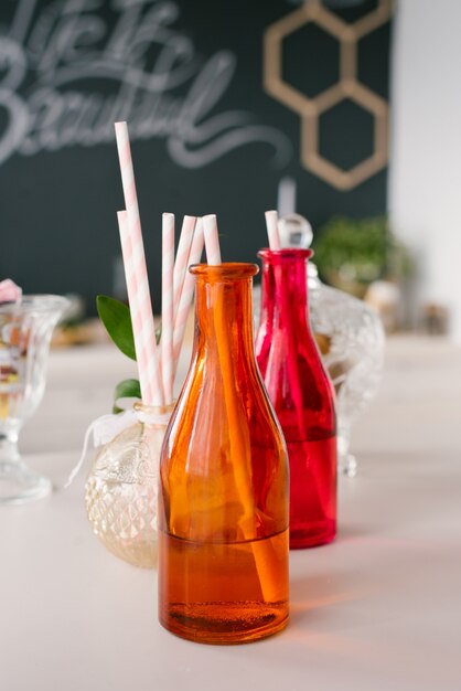 Premium Photo Bright Colorful Glass Bottles With Paper Straws For