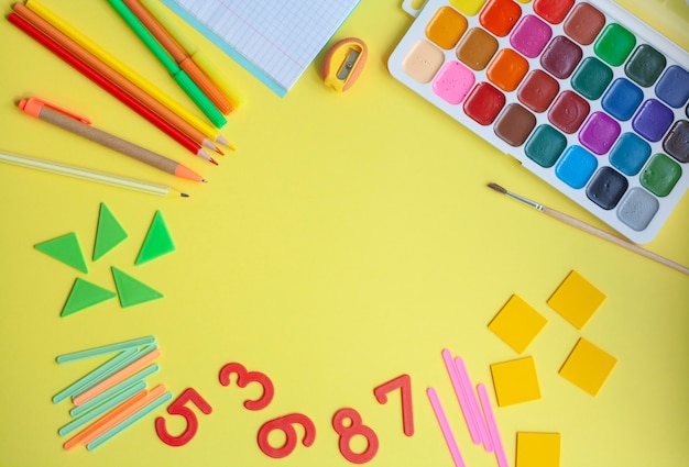 Premium Photo | Bright school background with school supplies on yellow ...