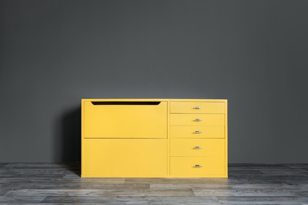 Bright Yellow Vintage Chest Of Drawers In The Room Near A Dark