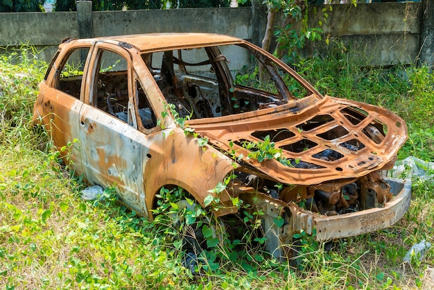 芝生での衝突事故で錆びた車が壊れた プレミアム写真