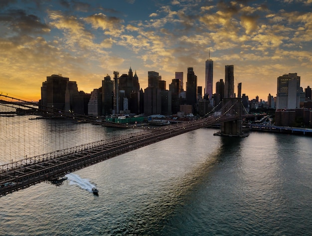 ブルックリン橋とマンハッタンの日没時のイーストリバー ニューヨーク プレミアム写真