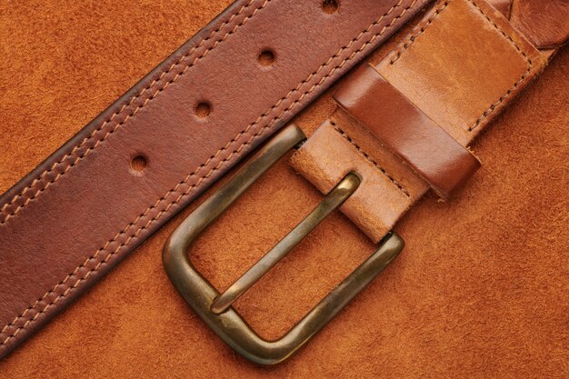 Premium Photo | Brown leather belt with bronze buckle on chamois leather