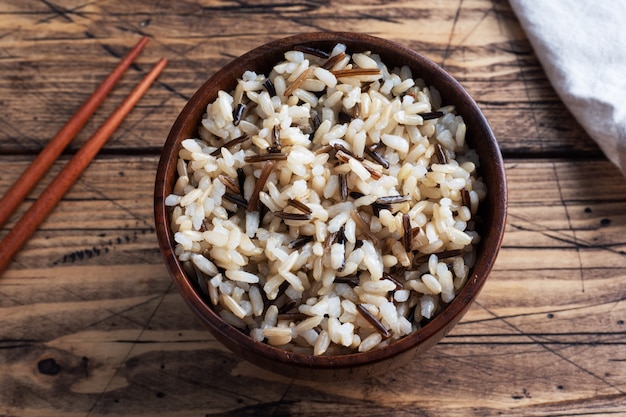 Premium Photo Brown And Unpeeled Rice On A Plate With Chopsticks