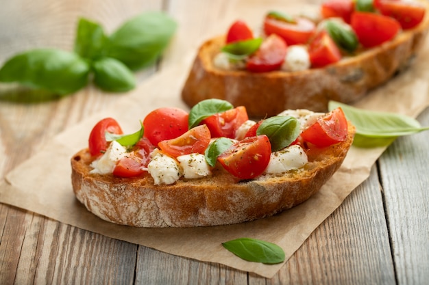 Premium Photo | Bruschetta with tomatoes, mozzarella cheese and basil.