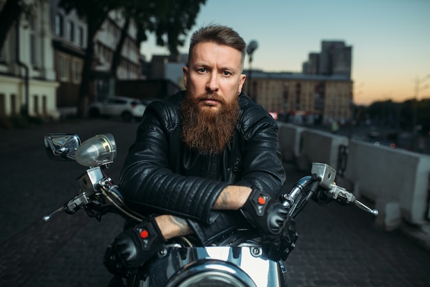 Premium Photo | Brutal bearded biker poses on chopper, front view