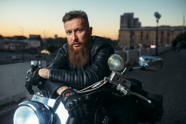 Premium Photo | Brutal bearded biker poses on chopper, front view