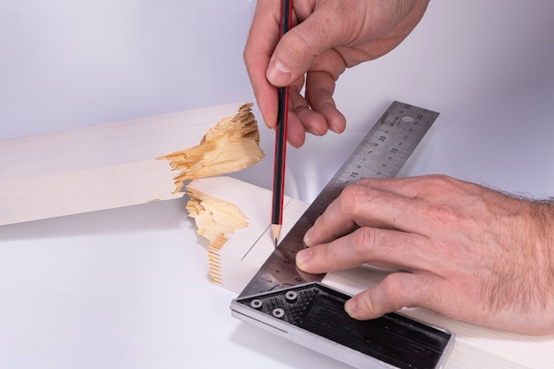 Premium Photo | Builder draws a line with a pencil on a broken board ...