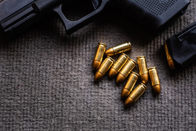 Premium Photo | Bullets and gun on black velvet desk