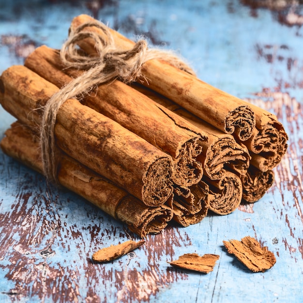 Premium Photo | Bunch of fresh indian cinnamon sticks on blue wooden table