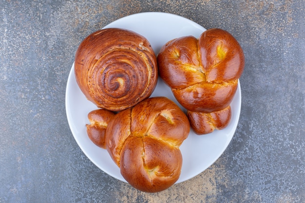 Free Photo | Bunch of sweet buns on a platter on marble surface