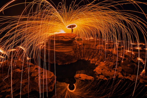 premium-photo-burning-steel-wool-on-the-rock-near-the-river