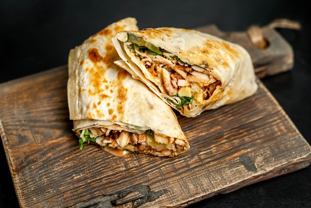 Premium Photo | Burrito wraps with chicken and vegetables on a cutting ...