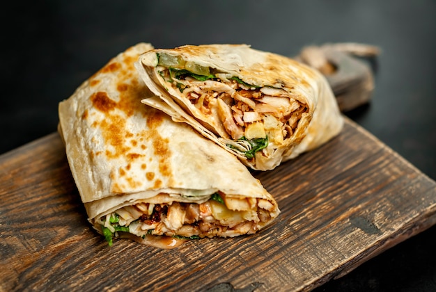 Premium Photo | Burrito wraps with chicken and vegetables on a cutting ...