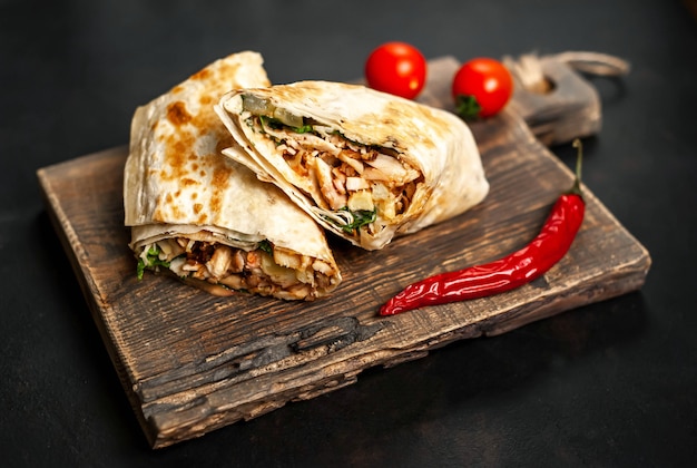 Premium Photo | Burrito wraps with chicken and vegetables on a cutting ...