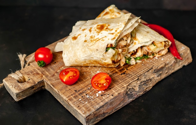 Premium Photo | Burrito wraps with chicken and vegetables on a cutting ...