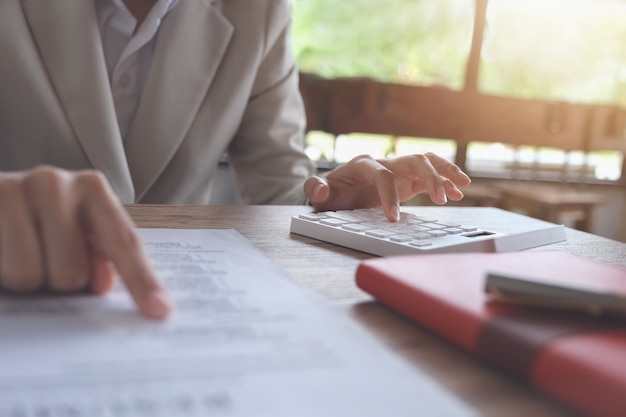 Business accounting concept, business man using calculator to calculating budget and loan paper in office. Premium Photo