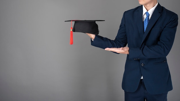 Business man is holding graduation hat, business education concept Premium Photo