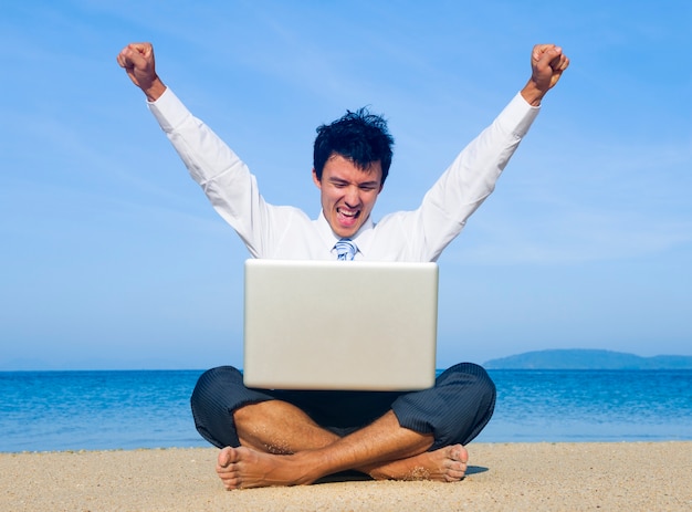 Business man on beach with laptop Free Photo