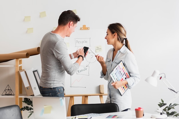 Business man and woman looking at a company diagram Free Photo