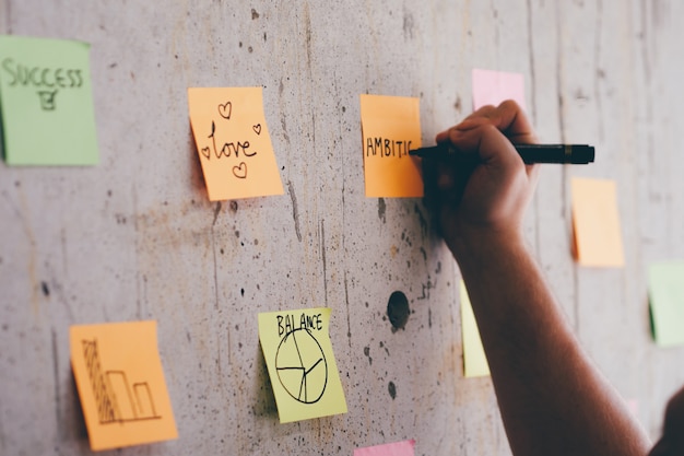 Business Man Writing Message On Post It Note. 