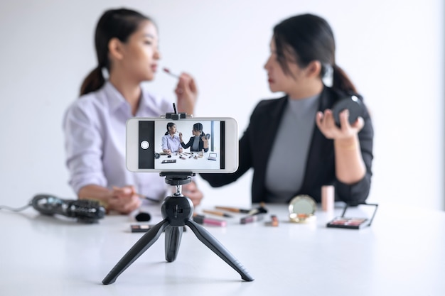 Premium Photo | Business online on social media, two beautiful woman  blogger is showing present tutorial beauty cosmetic product and broadcast  live streaming video to social network while recording teaching online