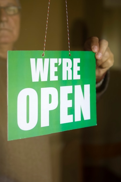 Download Free Business Owner Hanging An Open Sign At A Glass Door Premium Photo Use our free logo maker to create a logo and build your brand. Put your logo on business cards, promotional products, or your website for brand visibility.
