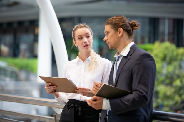 Business people discussing while standing on footbridge Premium Photo
