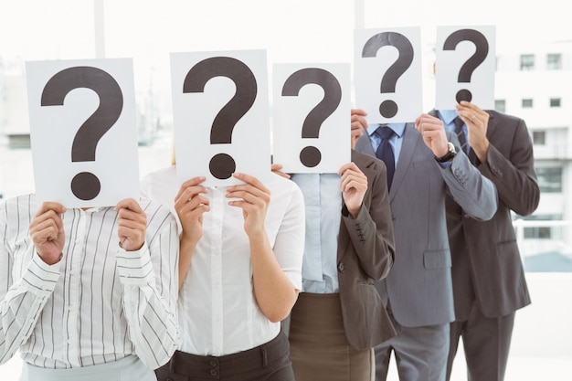 Business People Holding Question Mark Signs In Office