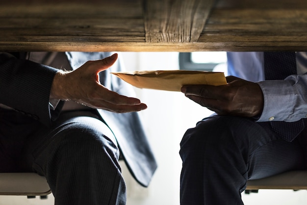 Business people sending documents under the table Premium Photo
