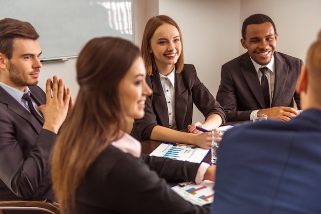 Business people sit at a table and discuss something ...