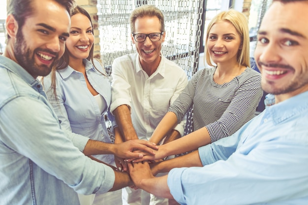 Premium Photo | Business team in casual clothes is holding hands together.