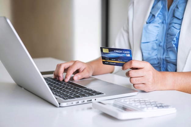 Business woman consumer holding credit card and typing on laptop for online shopping and payment make a purchase on the internet, online payment, networking and buy product technology Premium Photo