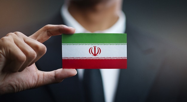 Businessman holding card of iran flag Premium Photo