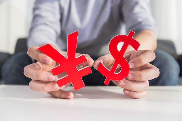 free-photo-businessman-holding-dollar-sign-and-cny-sign